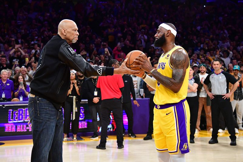 © Reuters. Feb 7, 2023; Los Angeles, California, USA; Former Los Angeles Lakers player Kareem Abdul-Jabbar hands the game ball to forward LeBron James (6) after James becomes the NBA all time scoring leader against the Oklahoma City Thunder during the second half at Crypto.com Arena. /Gary A. Vasquez-USA TODAY Sports