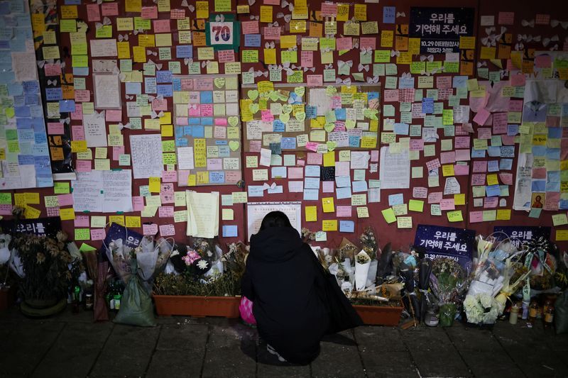&copy; Reuters. Une femme lit des messages de condoléances attachés au mur d'une étroite ruelle d'Itaewon où s'est produit la bousculade meurtrière d'Halloween qui a fait plus de 150 morts en octobre, à Séoul, en Corée du Sud. /Photo prise le 18 décembre 2022/RE