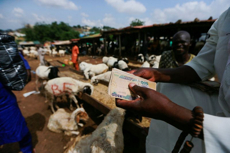 &copy; Reuters. A man holds money in his hand at the animal market in Karu, Abuja, Nigeria, July 8, 2022. REUTERS/Afolabi Sotunde