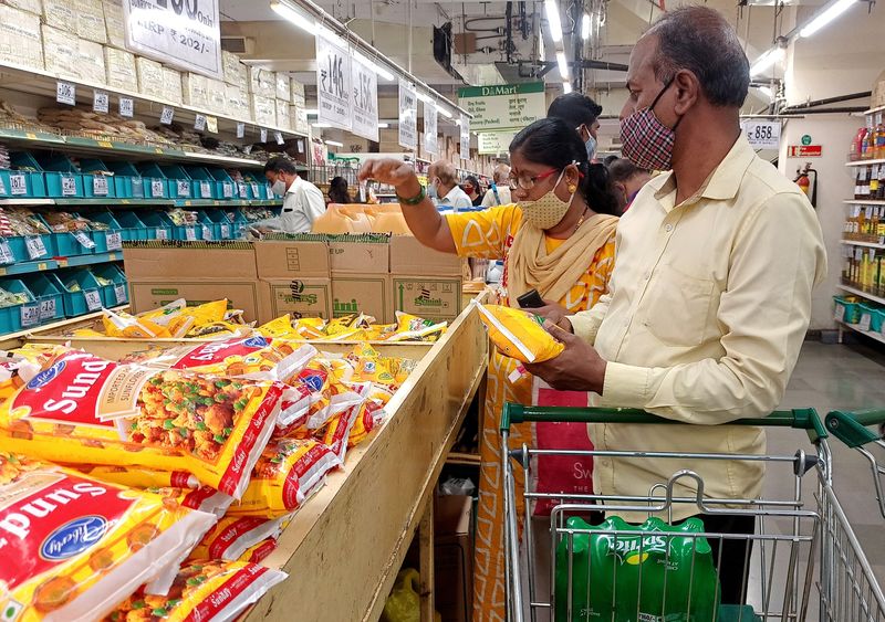 &copy; Reuters. FILE PHOTO: Shoppers purchase packets of vegetable oil at a supermarket in Mumbai, India, March 7, 2022. REUTERS/Rajendra Jadhav