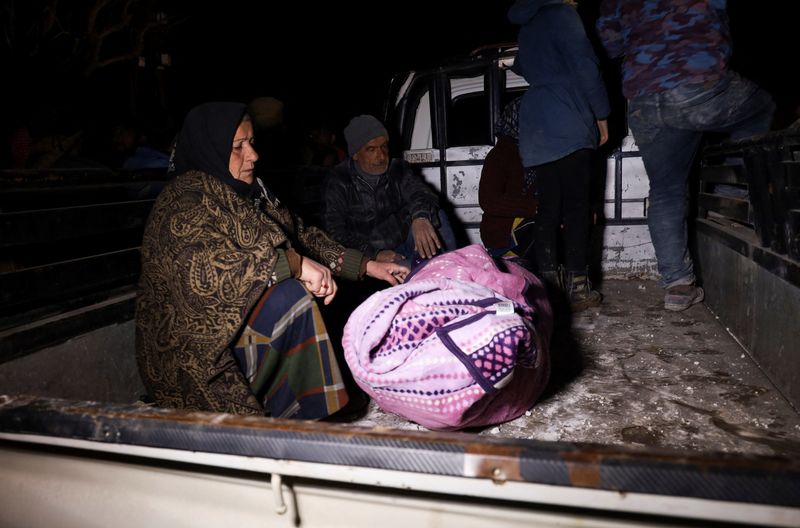 &copy; Reuters. Dolientes sentados en la parte trasera de un camión junto al cadáver de un familiar que fue sacado de entre los escombros, tras un terremoto, en la ciudad siria de Jindires, controlada por los rebeldes. 8 de febrero de 2023. REUTERS/Ameer Hurputlu  