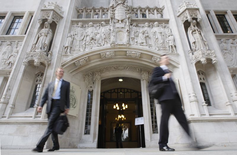 &copy; Reuters. شخصان يسيران أمام مقر المحكمة العليا في لندن. صورة من أرشيف رويترز.