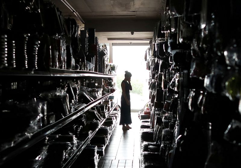 &copy; Reuters. FILE PHOTO: A shopper looks for goods during an electricity load-shedding blackout in Johannesburg, South Africa, February 12, 2019. REUTERS/Mike Hutchings/File Photo