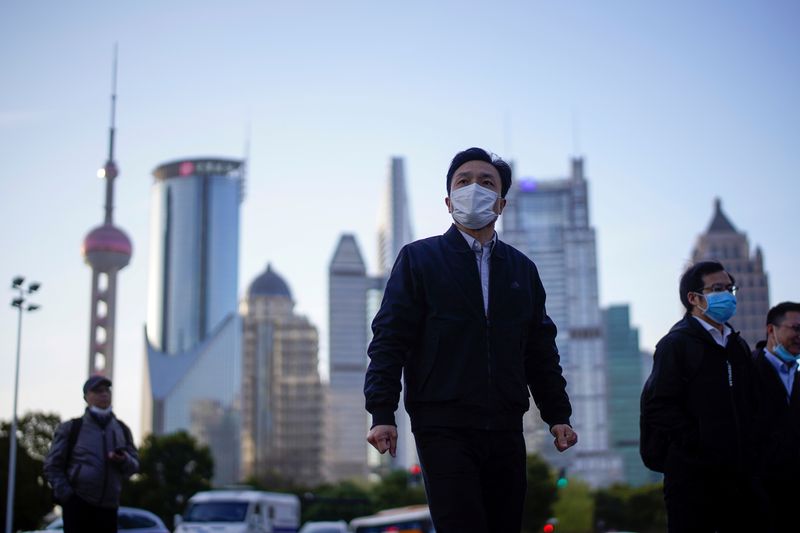 &copy; Reuters. أشخاص يضعون كمامات يسيرون في الشارع في مدينة شنغهاي بالصين في صورة من أرشيف رويترز.