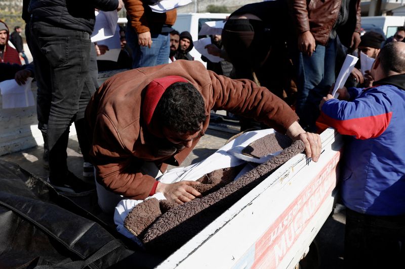 &copy; Reuters. Familiares rodean un camión que transporta cuerpos de sirios muertos en un terremoto en Turquía, a su llegada al paso fronterizo de Cilvegozu, Turquía. 8 de febrero, 2023. REUTERS/Benoit Tessier