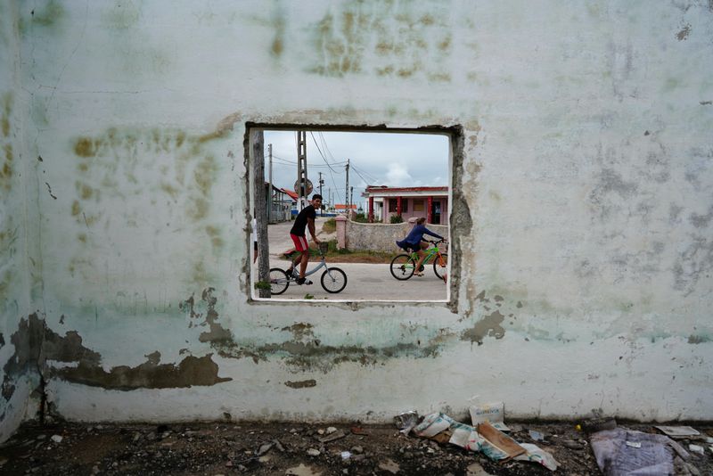 © Reuters. FILE PHOTO: Children riding bicycles pass by an abandoned building in Isabela de Sagua, Cuba, January 28, 2023.    REUTERS/Alexandre Meneghini     