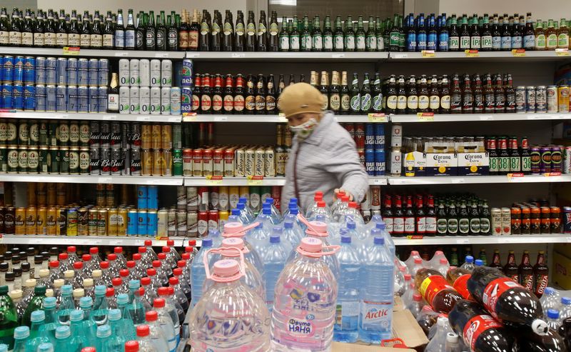 &copy; Reuters. FILE PHOTO: A customer walks past shelves with bottles and cans of beer in a supermarket amid the coronavirus disease (COVID-19) pandemic in Moscow, Russia April 8, 2020. REUTERS/Maxim Shemetov