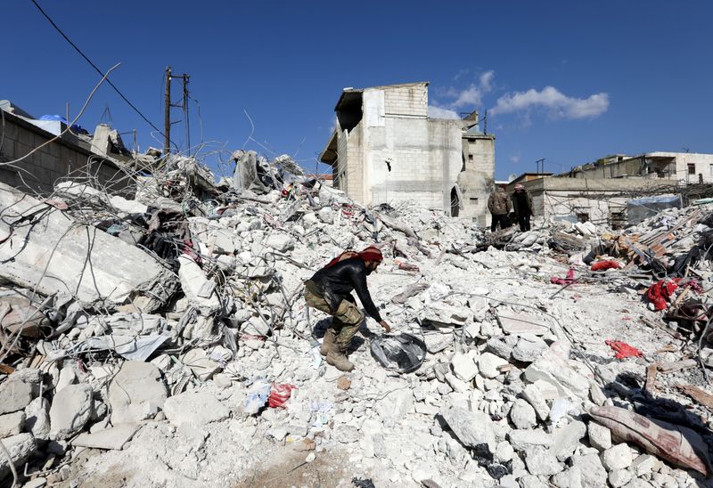 © Reuters. Salah al-Haji al-Akab, the brother in-law of Abdulrahman Ali al-Mahmoud, stands on a pile of rubble  that was once Mahmoud's home, in rebel-held town of Jandaris, Syria February 8, 2023.  REUTERS/Khalil Ashawi