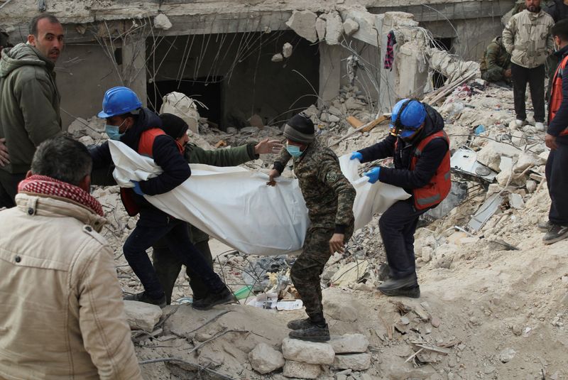 &copy; Reuters. أعضاء فريق الإنقاذ يحملون جثة في موقع مبنى مدمر في أعقاب الزلزال في مدينة حلب بسوريا يوم الأربعاء. تصوير: فراس مقدسي - رويترز.