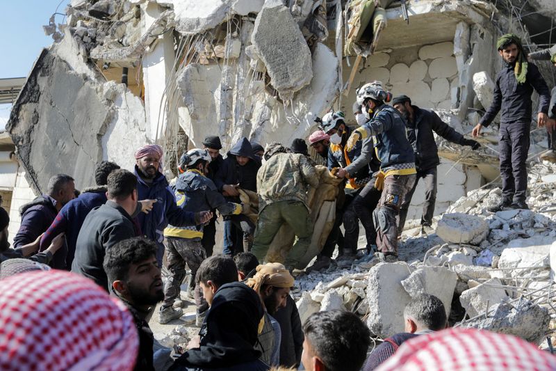 &copy; Reuters. عمال الإنقاذ يحملون أحد ضحايا الزلزال مع استمرار البحث عن ناجين في أعقاب الزلزال ببلدة جندريس بسوريا يوم الثلاثاء. تصوير: خليل عشاوي -رويترز