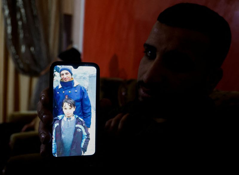 &copy; Reuters. أحد أقارب عبد الكريم أبو جلهوم الذي توفي هو جميع أفراد أسرته في زلزال تركيا يعرض صورته على الهاتف في منزل العائلة  ببيت لاهيا  في قطاع غزة يوم