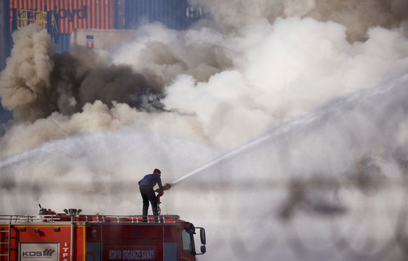 © Reuters. Un bombero trabaja en el puerto de Iskenderun, donde se declaró un incendio tras un terremoto mortal, en Turquía. 8 de febrero de 2023. REUTERS/Guglielmo Mangiapane  