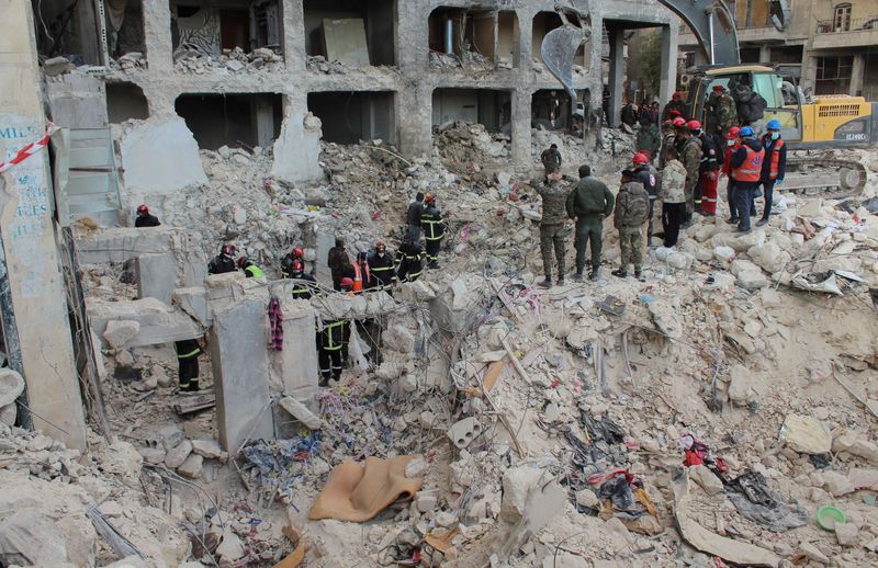 © Reuters. أفراد من فريق الإنقاذ الجزائري وجنود من الجيش السوري يبحثون عن ناجين في موقع مبان مدمرة في أعقاب زلزال في حلب يوم الأربعاء. تصوير: فراس مقدسي - رويترز