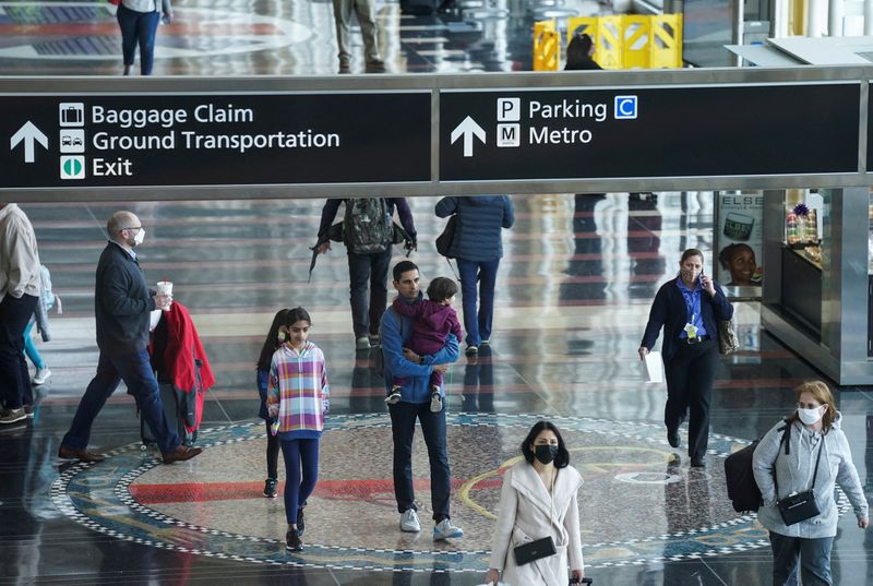 &copy; Reuters. FILE PHOTO: A mix of masked and unmasked travelers make their way through Ronald Reagan Washington National Airport after the Biden administration announced it would no longer enforce a U.S. coronavirus disease (COVID-19) mask mandate on public transporta