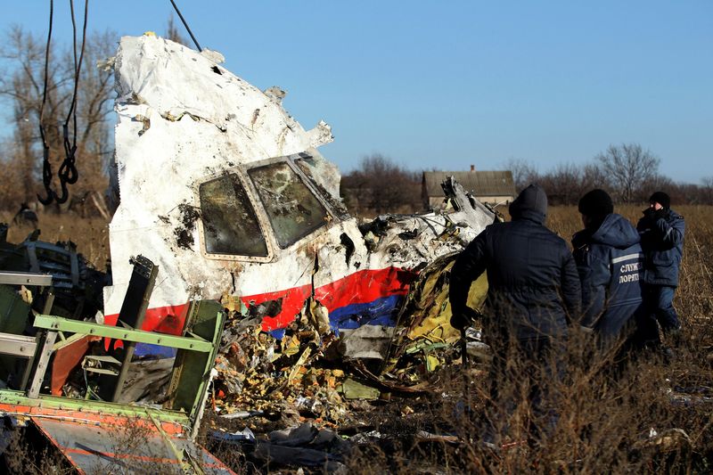 &copy; Reuters. FOTO DE ARCHIVO. Trabajadores locales transportan un trozo de restos del vuelo MH17 de Malaysia Airlines en el lugar donde se estrelló el avión, cerca del pueblo de Hrabove, Grabovo, en la región de Donetsk, en el este de Ucrania. 20 de noviembre de 20