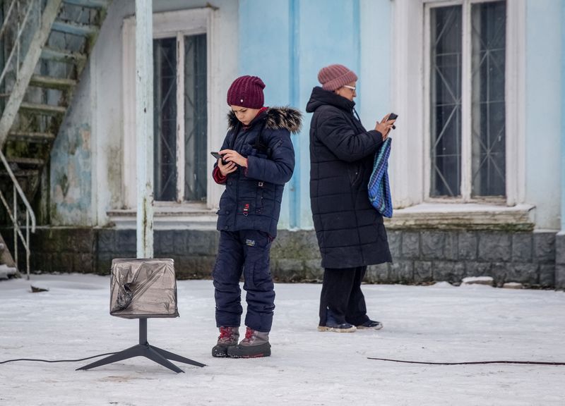 &copy; Reuters. FOTO DE ARCHIVO: Residentes locales utilizan una terminal Starlink, en medio del ataque de Rusia a Ucrania, en Chasiv Yar, región de Donetsk, Ucrania 31 de enero de 2023. REUTERS/Oleksandr Ratushniak/Foto de archivo