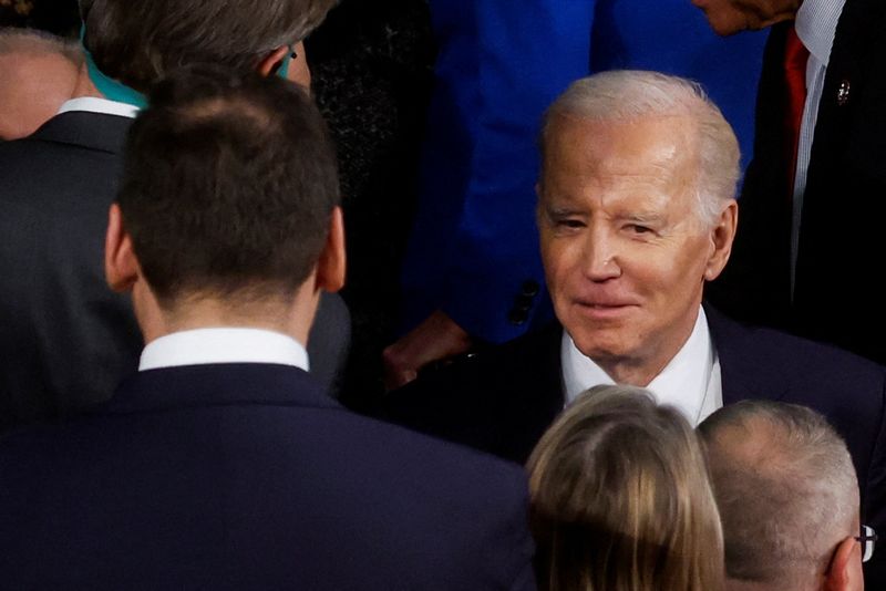 © Reuters. FILE PHOTO: U.S. President Joe Biden walks past members of Congress, including U.S. Rep. George Santos (R-NY) (L), as he arrives in the House Chamber to deliver his State of the Union address to a joint session of Congress at the U.S. Capitol in Washington, U.S., February 7, 2023. REUTERS/Evelyn Hockstein