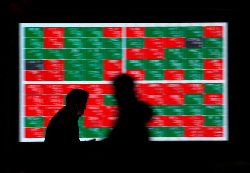 &copy; Reuters. FILE PHOTO: Passersby walk past an electric stock quotation board outside a brokerage in Tokyo, Japan, December 30, 2022. REUTERS/Issei Kato