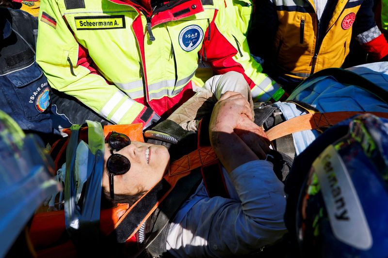 © Reuters. Rescuers carry a woman named Zeynep, as the search for survivors continues, in the aftermath of a deadly earthquake in Kirikhan, Turkey February 10, 2023. REUTERS/Piroschka van de Wouw