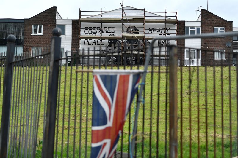 &copy; Reuters. FILE PHOTO: A Union flag hangs on railings near a mural reading "prepared for peace, ready for war" is seen on the side of a building in the Mount Vernon area of Belfast, Northern Ireland June 21, 2022. REUTERS/Clodagh Kilcoyne
