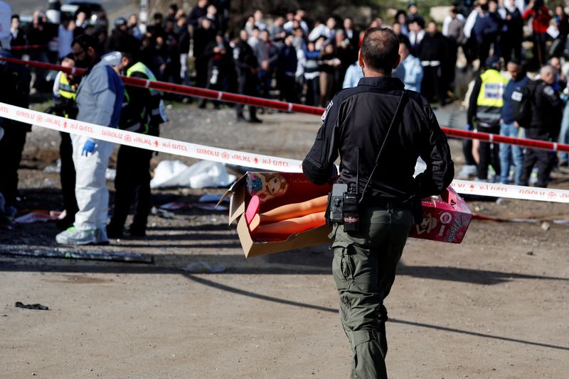 &copy; Reuters. Un policier israélien transporte une grande poupée en plastique sur les lieux d'un attentat présumé à la voiture bélier à Jérusalem, le 10 février 2023. /REUTERS/Ammar Awad