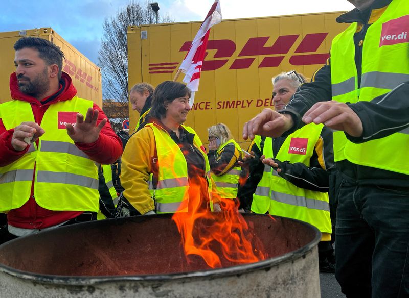 &copy; Reuters. FILE PHOTO: Workers stand beside a fire barrel during a nationwide warning strike at the German mail carrier Deutsche Post in Cologne, Germany, January 20, 2023. REUTERS/Erol Dogrudogan