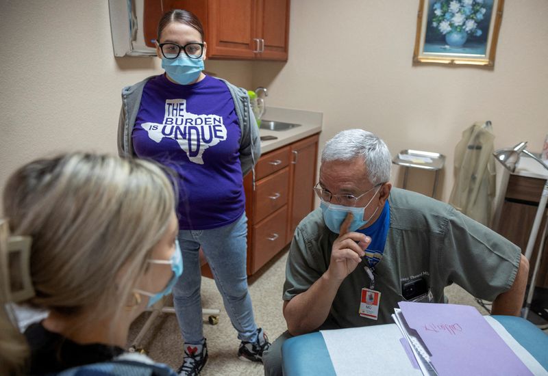 © Reuters. Dr. Franz Theard speaks to a patient with medical assistant Elizabeth Hernandez, at his clinic, Women's Reproductive Clinic of New Mexico in Santa Teresa, U.S., January 13, 2023. REUTERS/Evelyn Hockstein