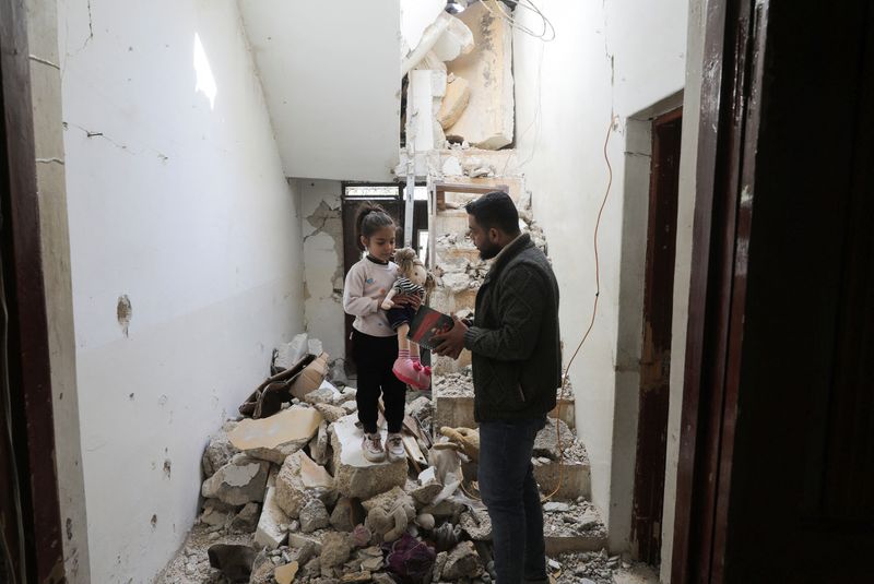 © Reuters. Ramadan al-Suleiman, manager of kawkab al-Tofoula (Children's Planet) nursery that was damaged in the quake, visits Lafeen, one of his nursery's pupils, as he inspects her damaged house, in the aftermath of an earthquake, in rebel-held town of Jandaris, Syria February 12, 2023.  REUTERS/Khalil Ashawi