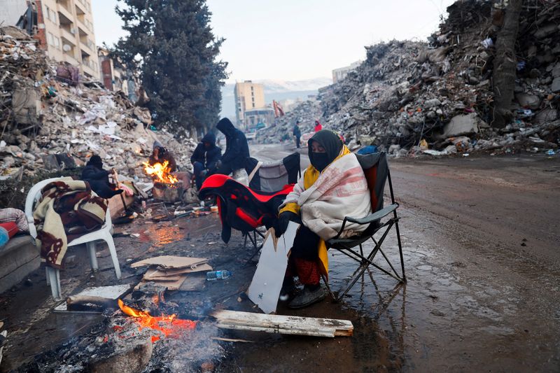 &copy; Reuters. Una persona se calienta junto a un fuego mientras continúa la búsqueda de supervivientes tras un mortífero terremoto en Kahramanmaras, Turquía 13 de febrero de 2023. REUTERS/Suhaib Salem      