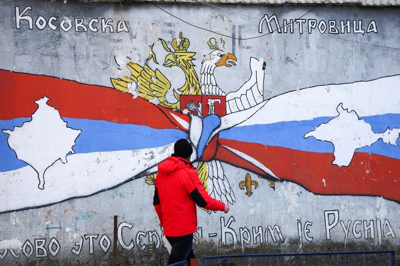 &copy; Reuters. FILE PHOTO: A person walks past a graffiti in the northern part of the ethnically-divided town of Mitrovica, Kosovo, February 6, 2023.  REUTERS/Florion Goga