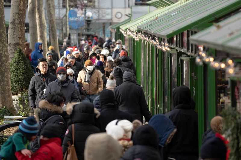 &copy; Reuters. FILE PHOTO: People wearing masks walk around the Bryant Park Winter Village on Christmas Eve in Manhattan, New York City, U.S., December 24, 2022. REUTERS/Jeenah Moon