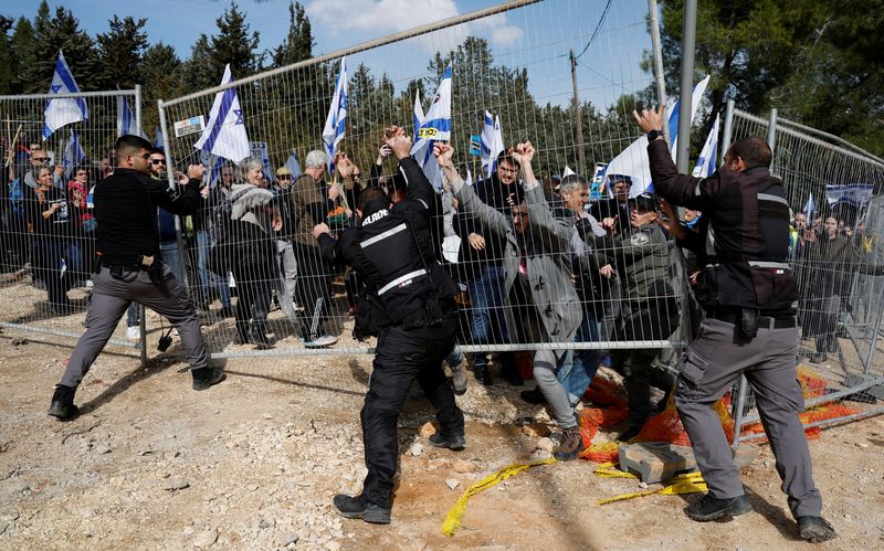 &copy; Reuters. Israeli protestors clash with Israeli police officers as they demonstrate on the day Israel's constitution committee is set to start voting on changes that would give politicians more power on selecting judges while limiting Supreme Court's powers to stri