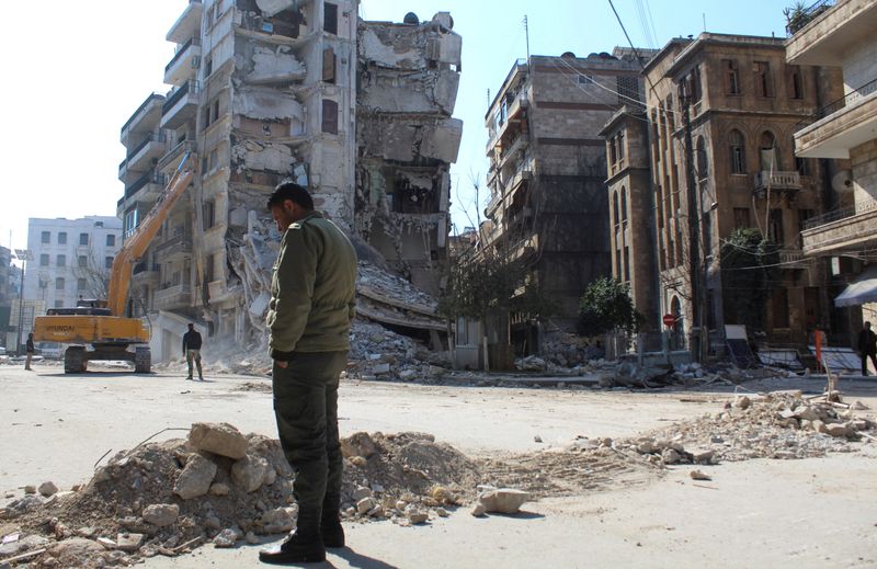 &copy; Reuters. رجل يقف قريبا من مبان متضررة في أعقاب الزلزال المدمر في حلب يوم 12 فبراير شباط عام 2023. تصوير: فراس مقدسي - رويترز
