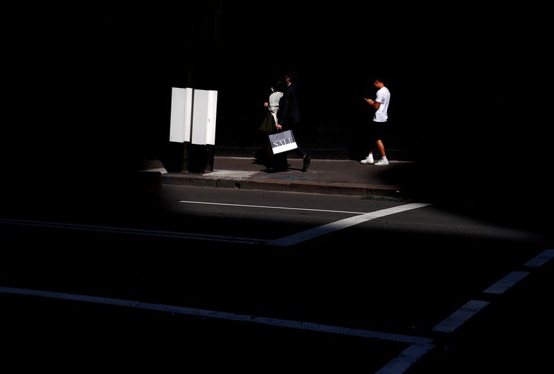 &copy; Reuters. FILE PHOTO: A man carries a bag displaying the word 'Sale' as he walks along a footpath with other pedestrians outside a retail store in central Sydney, Australia, September 11, 2018. Picture taken September 11, 2018.     REUTERS/David Gray     