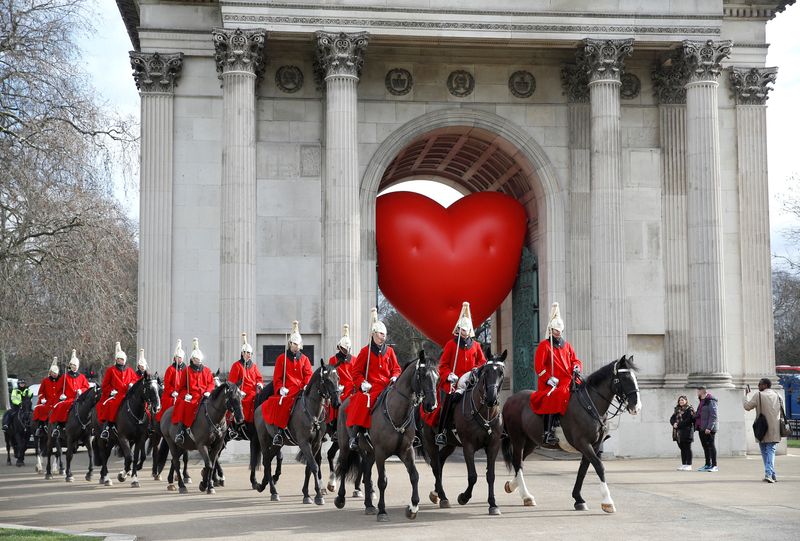 © Reuters. FILE PHOTO: Members of the Household Cavalry walk past Wellington Arch and a large inflatable heart, on Valentine's Day in London, Britain, February 14, 2022. REUTERS/Peter Nicholls/File Photo