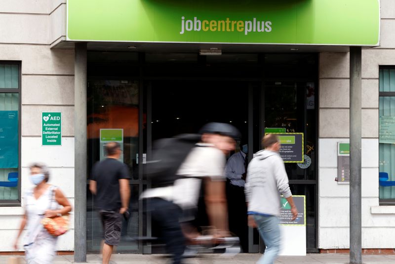 &copy; Reuters. FILE PHOTO: People walk past a branch of Jobcentre Plus, a government run employment support and benefits agency, as the outbreak of the coronavirus disease (COVID-19) continues, in Hackney, London, Britain, August 6, 2020. REUTERS/John Sibley