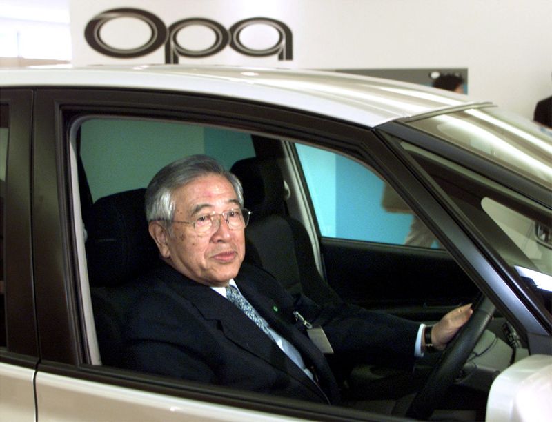&copy; Reuters. FILE PHOTO: The then Toyota Motor Corporation's Honorary Chairman Shoichiro Toyoda sits in the driver's seat of its new midsize vehicle Opa after unveiling the car in Tokyo May 24, 2000./File Photo