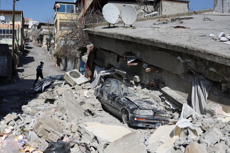 © Reuters. رجل يسير بجوار منزل مدمر جراء الزلزال المدمر الذي وقع في كهرمان مرعش بتركيا يوم الثلاثاء. تصوير: نير إلياس - رويترز.