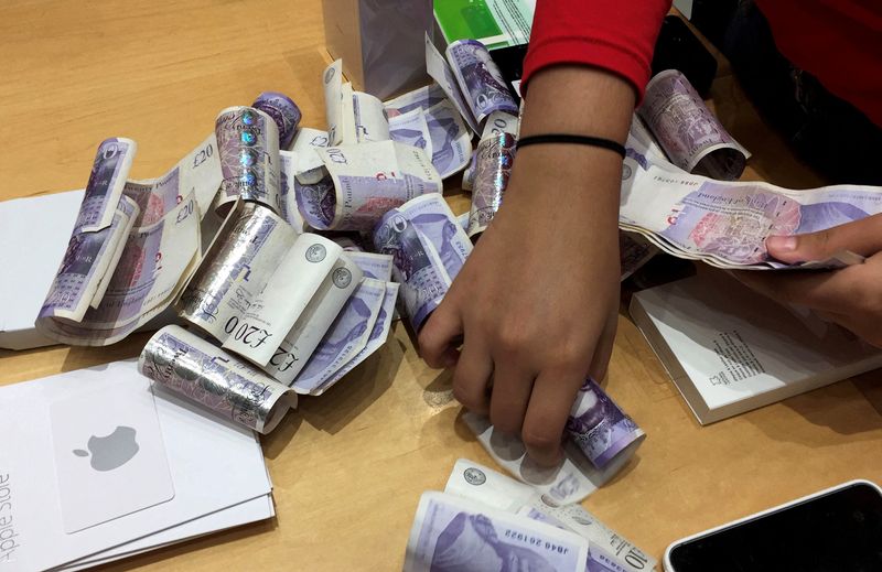 &copy; Reuters. FILE PHOTO: A shop assistant counts piles of British Pound Sterling banknotes at an Apple store in London, Britain November 18, 2017. REUTERS/Russell Boyce/File Photo