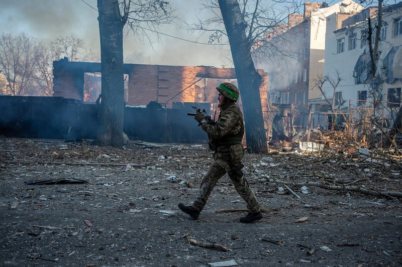 &copy; Reuters. Soldado ucraniano caminha em frente a prédio em chamas na cidade de Bakhmut, na linha de frente da guerra
13/02/2023 Forças Armadas da Ucrânia/Divulgação via REUTERS