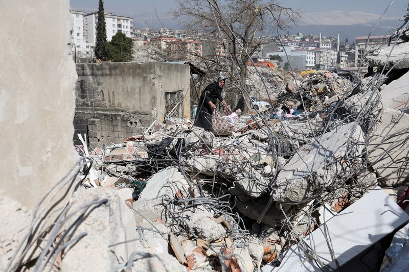 &copy; Reuters. امرأة تجلب متعلقاتها من حطام منزلها في كهرمان مرعش بتركيا يوم الثلاثاء. تصوير: نير إلياس - رويترز. 