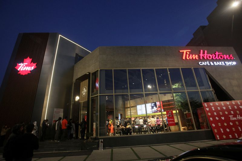 © Reuters. People wait for their turn to get in Tim Hortons Cafe and Bake Shop, in Lahore, Pakistan, February 14, 2023. REUTERS/Mohsin Raza