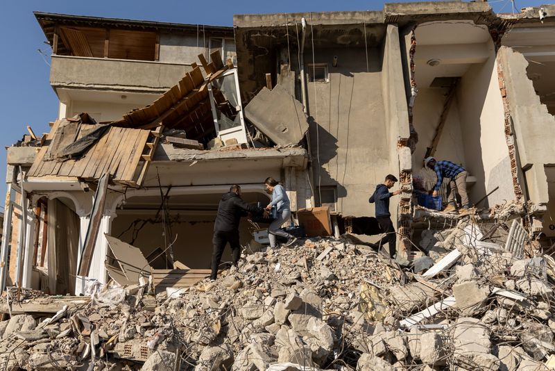 &copy; Reuters. Pessoas recolhem itens em escombros na província de Hatay, Turquia
14/02/2023
REUTERS/Eloisa Lopez