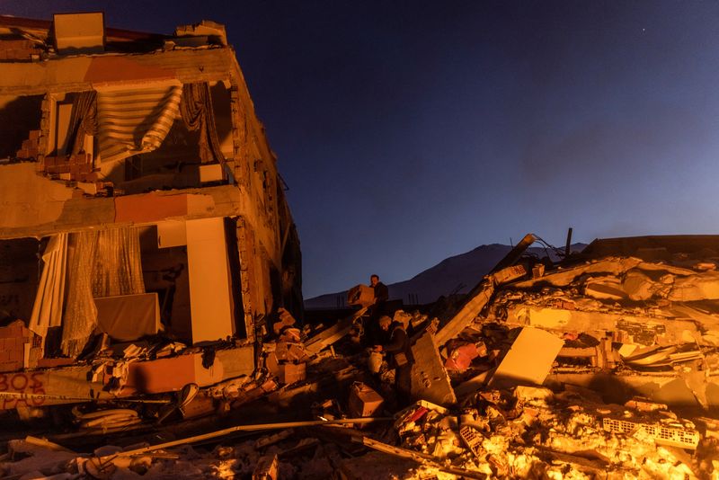 © Reuters. People gather boxes on the remains of a destroyed building in the aftermath of a deadly earthquake in Elbistan, Turkey February 14, 2023. REUTERS/Maxim Shemetov