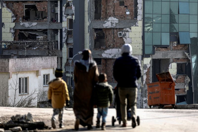 &copy; Reuters. أشخاص يسيرون بالقرب من مبنى مدمر في أعقاب الزلزال المميت في كهرمان مرعش بتركيا يوم 15 فبراير شباط 2023. تصوير: نير إلياس - رويترز.
