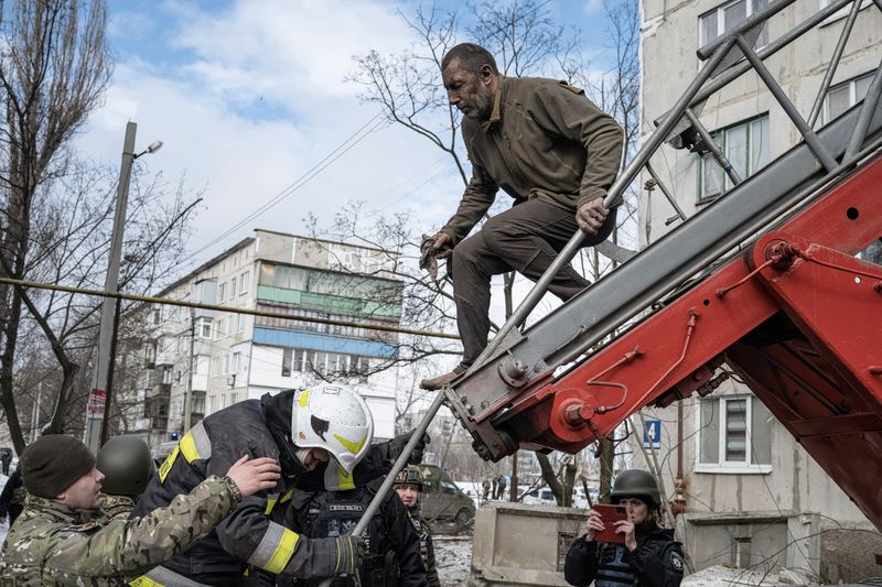 © Reuters. A man is rescued by firefighters after an apartment block was heavily damaged by a missile strike, amid Russia's attack on Ukraine, in Pokrovsk, Donetsk region, Ukraine, February 15, 2023. REUTERS/Marko Djurica