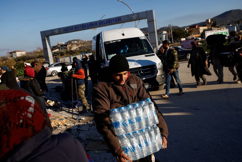 &copy; Reuters. شخص يحمل زجاجات مياه حصل عليها كمساعدات عقب الزلزال المدمر في هاتاي بتركيا في الثامن من فبراير شباط 2023. تصوير: جوجليلمو مانجيابان – رويترز.