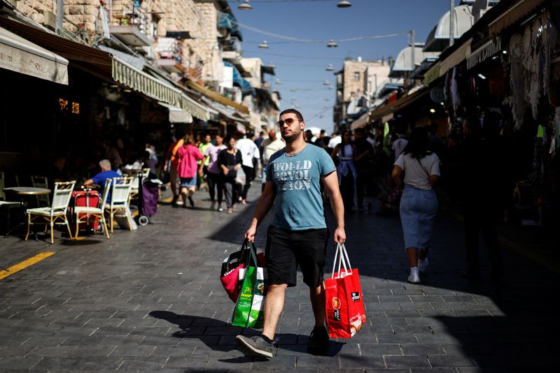 &copy; Reuters. FILE PHOTO: A man carries his groceries through Mahane Yehuda market in Jerusalem, September 30, 2022. REUTERS/Amir Cohen