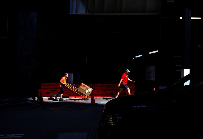 &copy; Reuters. FILE PHOTO: A worker pushes a trolley loaded with goods past a construction site in the central business district (CBD) of Sydney in Australia, March 15, 2018.REUTERS/David Gray