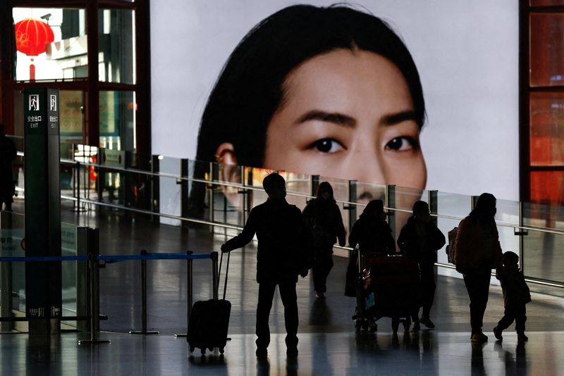 &copy; Reuters. FILE PHOTO: Travellers walk with luggages at a terminal hall, during the annual Spring Festival travel rush ahead of the Chinese Lunar New Year, as the coronavirus disease (COVID-19) outbreak continues, in Beijing Capital International Airport, Beijing, C
